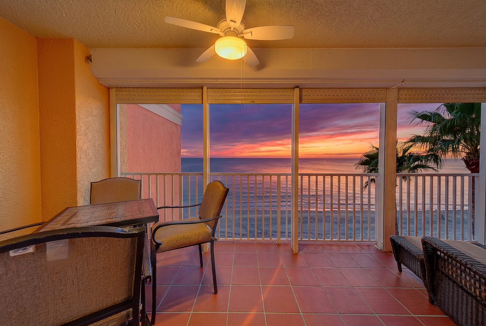 Sunset view from the balcony with ceiling fan and seating